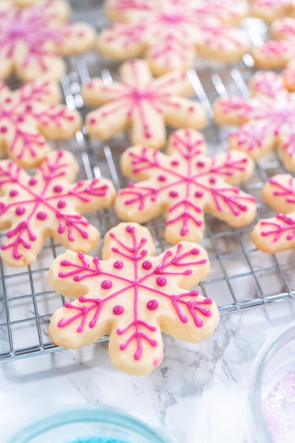 Decorating Christmas sugar cookies with royal icing and sprinkles.