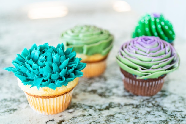 Decorating cupcakes with cactusshaped buttercream frosting