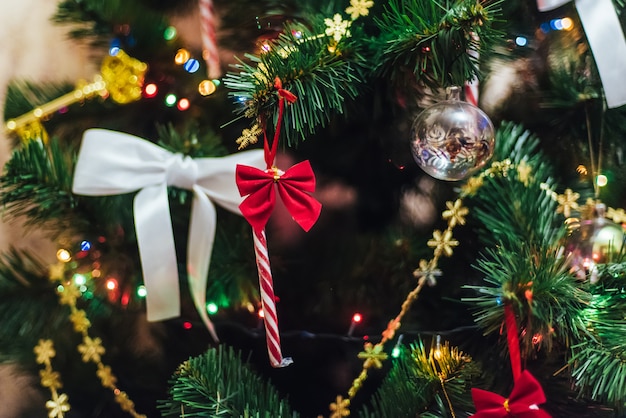 Decorations on Christmas tree with balls, garlands and bows