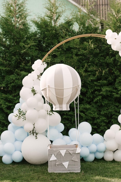 Decorations for holiday party A lot of balloons blue and white colors Round photo zone with balls next to a ball with a basket for a child