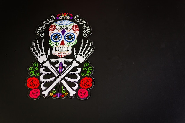 Decorations for traditional Mexican holiday Day of the Dead on a black background.