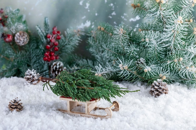 Decorative composition of Christmas decorations made of small fir tree on Santa Claus sleigh.