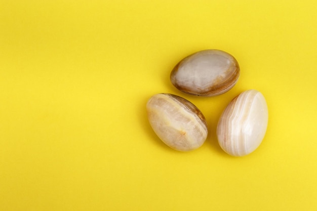 Decorative Easter eggs made from Natural gemstone onyx. Minimal flat lay background with copy space.