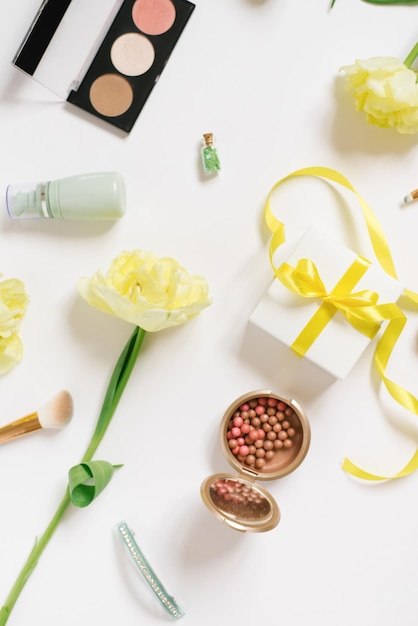 Decorative flat lay composition with cosmetics and flowers Flat lay top view on white background