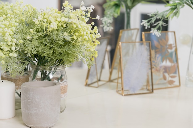 Decorative flowers candles and dried plants in frame on dressing table