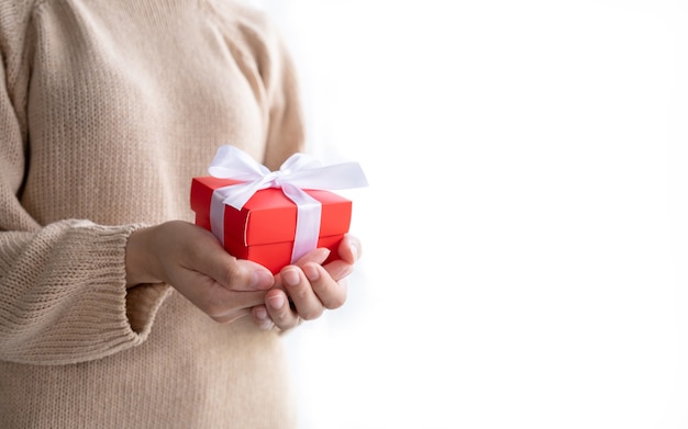 Decorative gift box with white bow ribbon. Gift in the hands of a woman. Typically used for birthday, anniversary presents, important days, christmas, new year, concept.