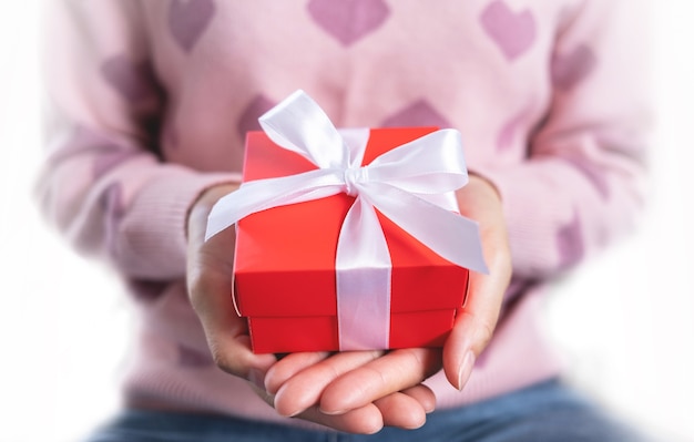 Decorative gift box with white bow ribbon. Gift in the hands of a woman. Typically used for birthday, anniversary presents, important days, christmas, new year, concept.