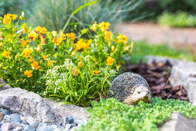 Decorative hedgehog garden decor Ceramic statue on a flowerbed