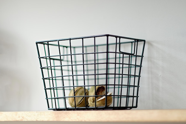 Decorative metal basket on a wooden shelf