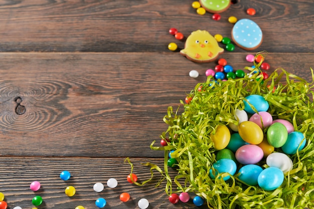 Decorative nest filled with easter eggs on wooden background