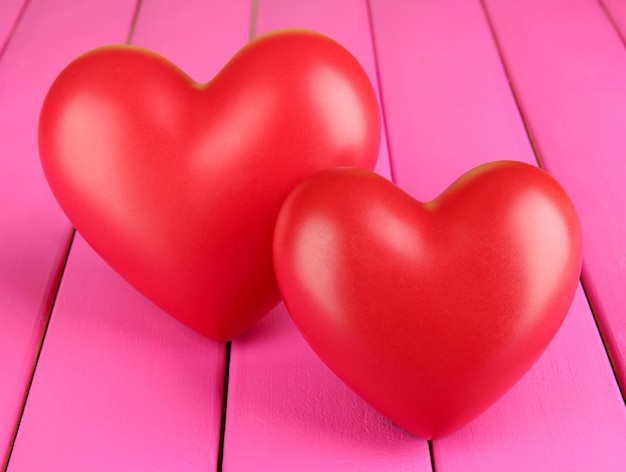 Decorative red hearts on color wooden background