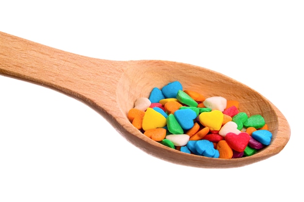 Decorative sprinkles sugar in a wooden spoon isolated on a white background