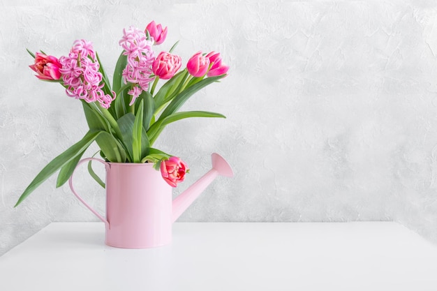 Decorative watering can with pink tulips Gardening