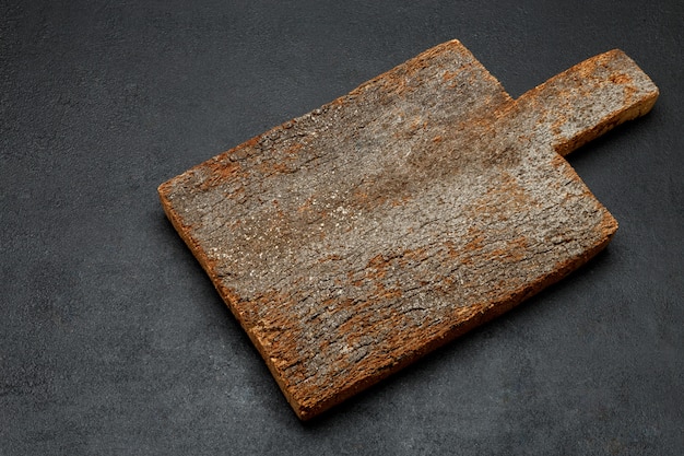 Decorative wooden serving or cutting board on concrete background