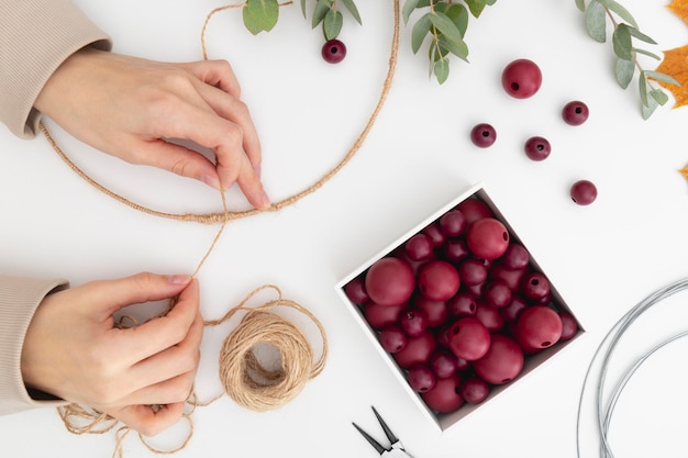 Decorative wreath made of twine and wire is creating by women's hands Tying a knot