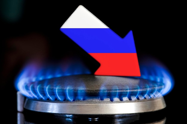 Decreased gas supplies Russia A gas stove with a burning flame and an arrow in the colors of the Russia flag pointing down Concept of crisis in winter and lack of natural gas Heating season