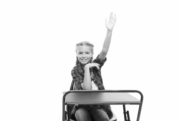 Photo dedicated to education small girl raising hand in school of primary education little child getting formal education cute schoolchild sitting at desk comprehensive or compulsory education is free