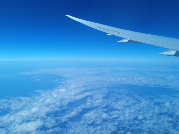 Deep blue sky and clouds with airplane wing