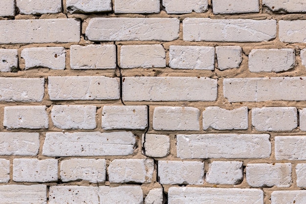 Deep cracked white silicate brick wall closeup texture and background