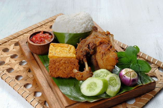 deep fried duck served with rice, vegetables and sambal (nasi bebek )-indonesian food style.