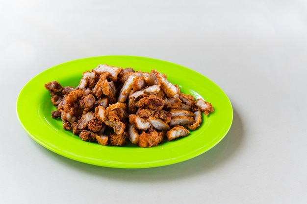 Deep fried golden color crispy pork belly plating on green plate.