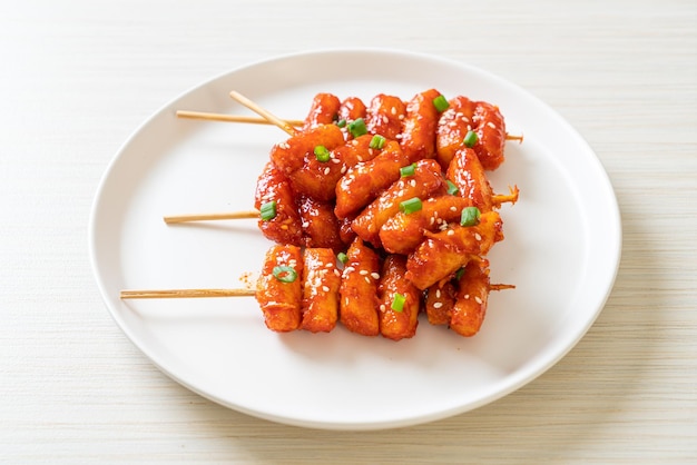 Deep fried Korean rice cake Tteokbokki skewered with spicy sauce