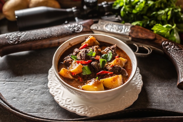 Deer stew in a bowl hunting weapon as a decoration.