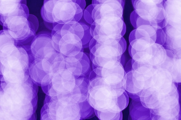 Defocused bokeh lights in blur night background. Colors of the year 2018 ultra violet pantone.