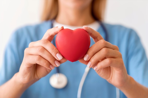 Defocused female doctor holding heart shape