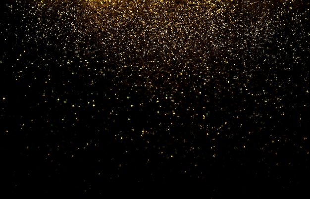 Defocused Glittery Golden Lights over Dark Background