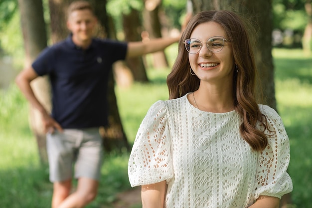 Defocused man focus on smiling woman in park among trees happy people having fun on summer day coupl