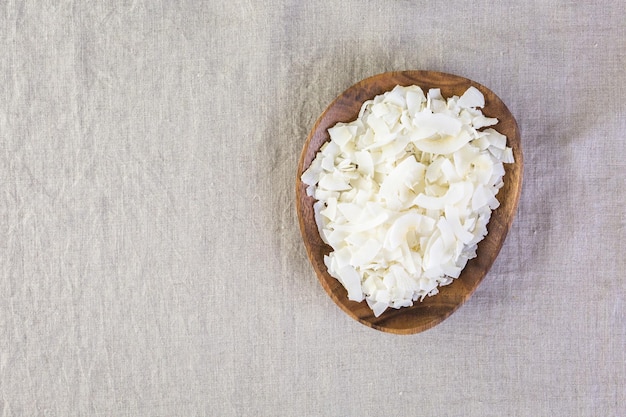 Dehydrated coconut flakes in wooden bowl.