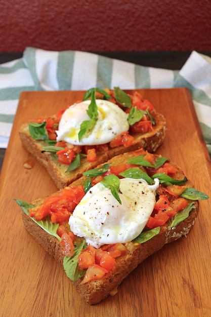 Delectable Freshly Cooked Poached Egg on Fresh Basil and Tomato Wholemeal Toast