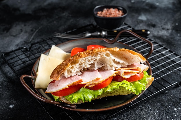 Deli meat sandwich with turkey ham cheese tomato and Lettuce Black background Top view