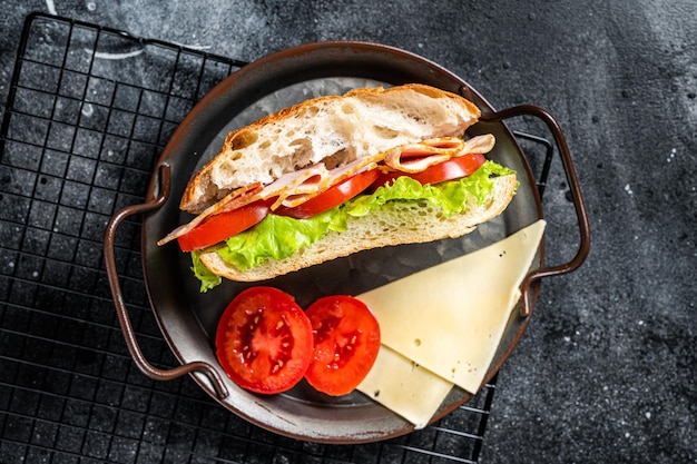 Deli meat sandwich with turkey ham cheese tomato and Lettuce Black background Top view