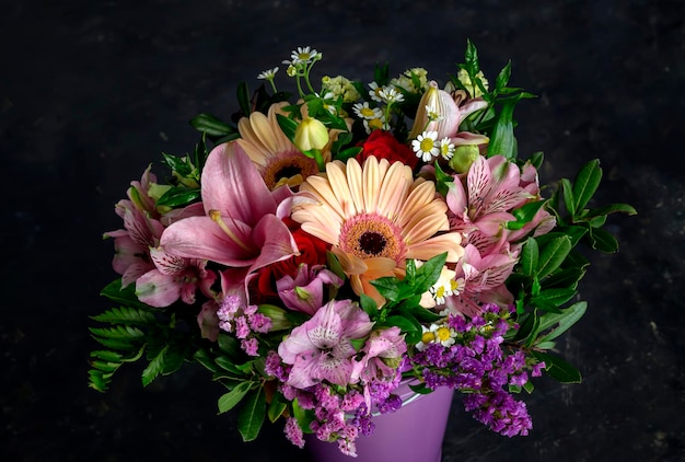 A delicate bouquet with a variety of flowers stands on the table