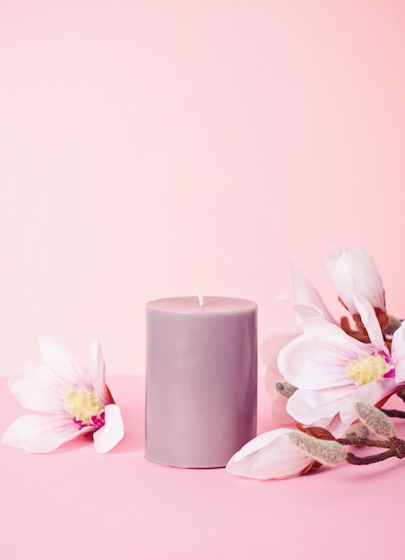 Photo delicate flower scented candle over pastel pink background