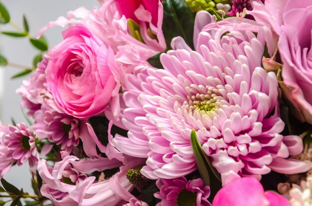 Delicate fresh bouquet of fresh flowers with a pink aster.