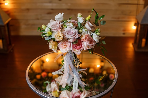 Delicate and very beautiful wedding bouquet of roses greenery eustoma standing on mirror table