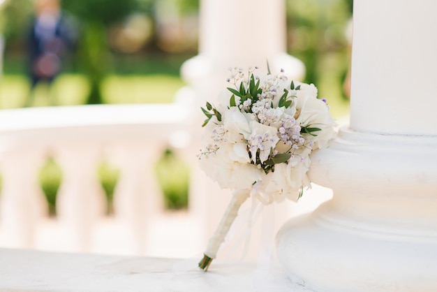 Delicate wedding bouquet with white hydrangea and greenery closeup