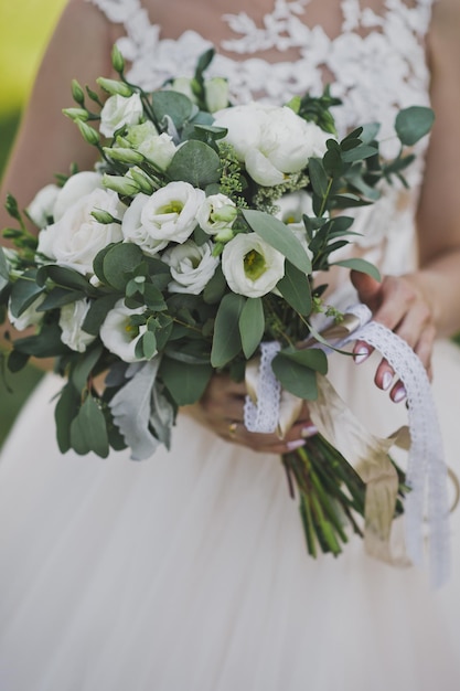 Delicate whitegreen wedding bouquet in the hands of the bride 2440