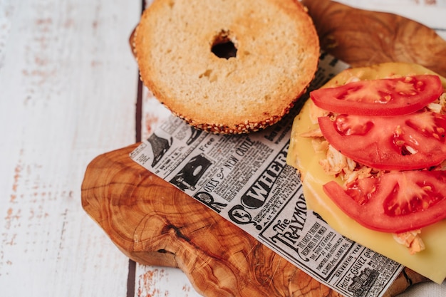 Delicious bagel with sesame and chia bread, inside it contains tomato, ham, fresh cheese and some freshly extracted slices of avocado.