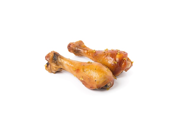 Delicious baked chicken drumsticks in honeymustard marinade isolated on white background