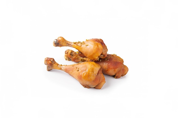 Delicious baked chicken drumsticks in honeymustard marinade isolated on white background