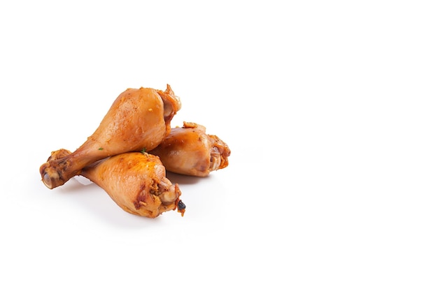 Delicious baked chicken drumsticks in honeymustard marinade isolated on white background