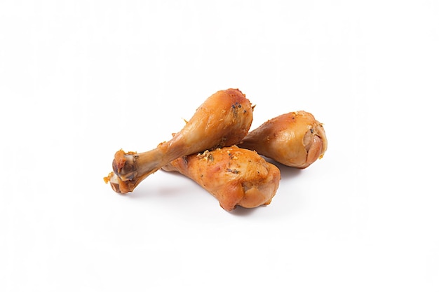 Delicious baked chicken drumsticks in honeymustard marinade isolated on white background