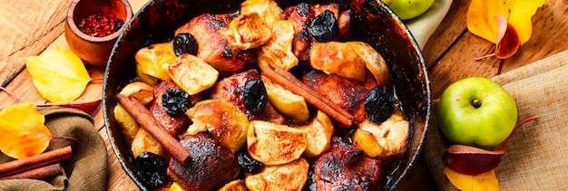 Delicious baked meat stew in apples on old wooden table