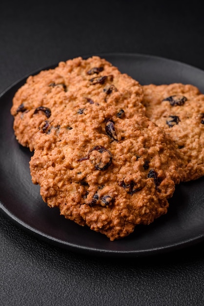 Delicious baked oatmeal raisin cookies on a dark concrete background