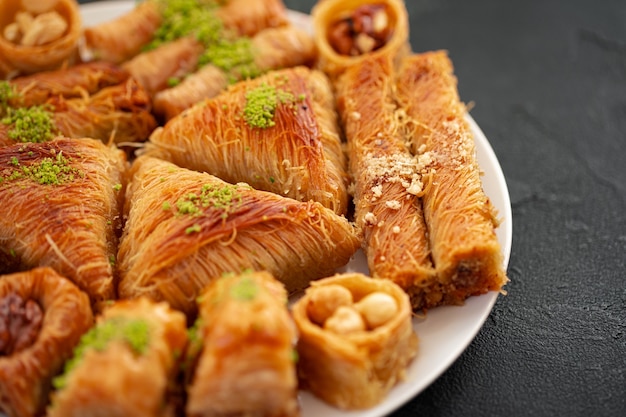 Delicious baklava dessert in oriental setting on black background, close up