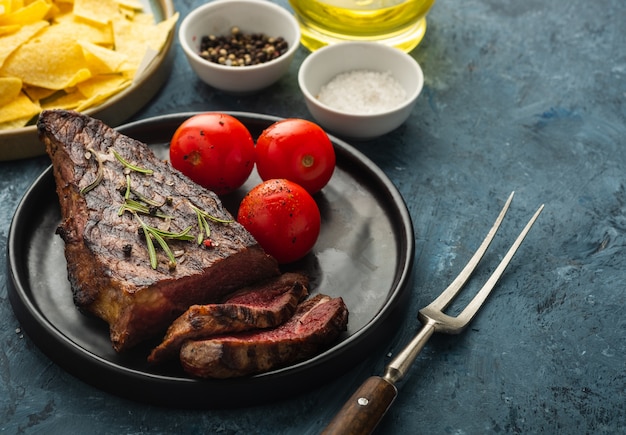 Delicious beef steak with salad, aromatic herbs, chery tomatoes